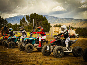 Four kids lining up to race on atvs