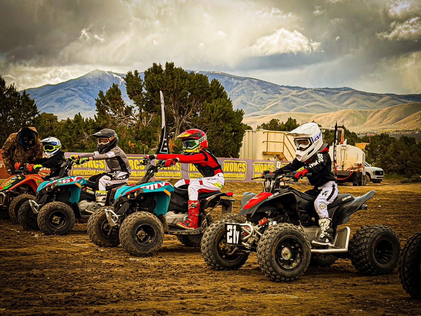 Four kids lining up to race on atvs